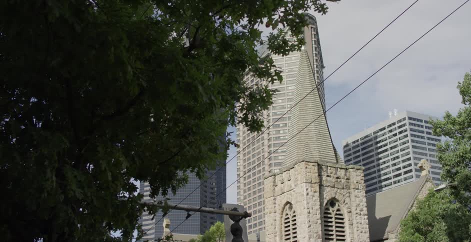 Church tower in front of skyscraper in city downtown