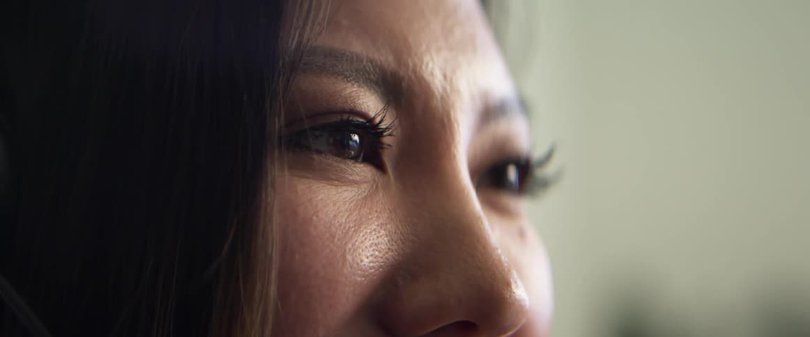 Close up of a womans eyes while talking in a room