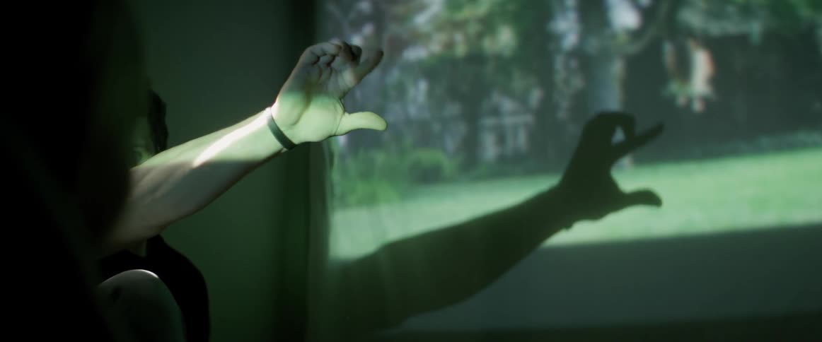 A man places his hand in the way of an overhead projector in order to make shadow puppets