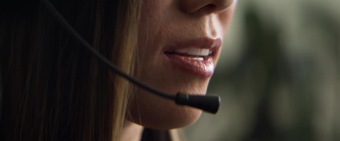 Woman talks into a headset microphone