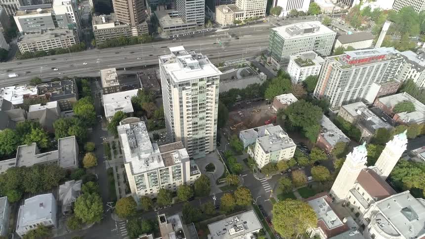 An aerial view of buildings in a city and cars driving down a street