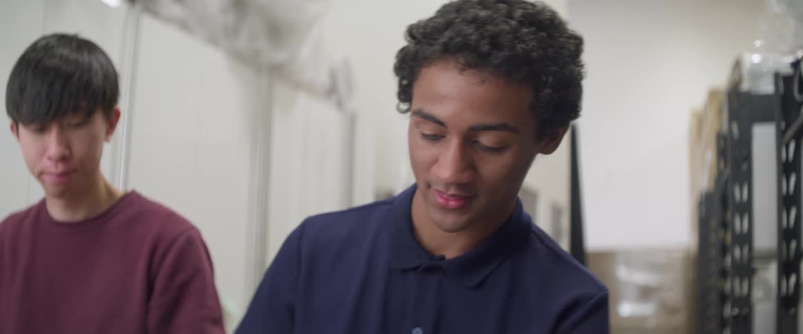 Two young men are standing near each other in a room
