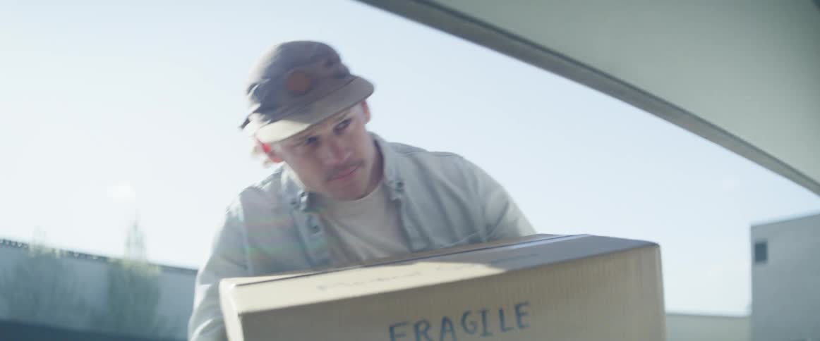 A man carries a box in to a garage