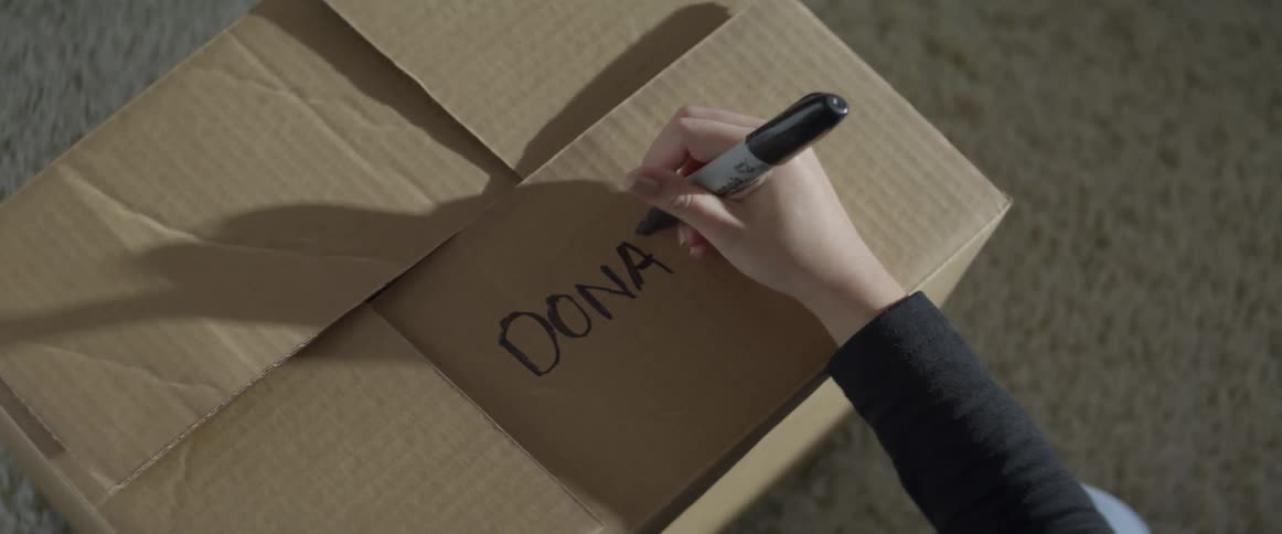 Person labels cardboard box for donation