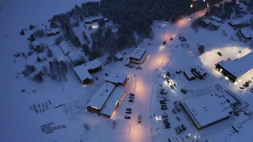 Cars are driving through a small town in an arctic area