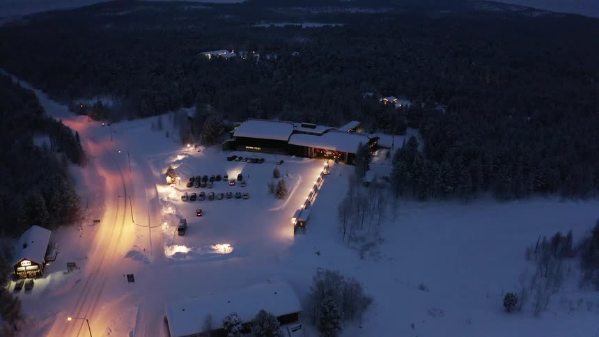 Aerial view of a building in a rural area with cars parked outside of it
