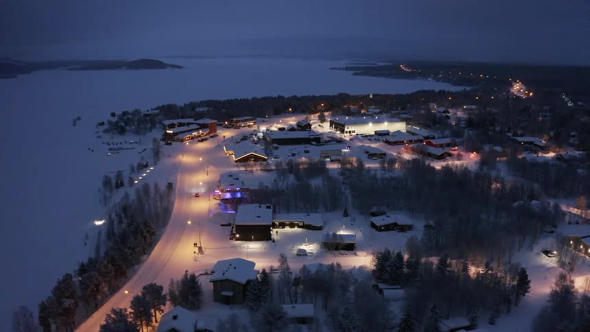 A small snow covered town lies near a forest