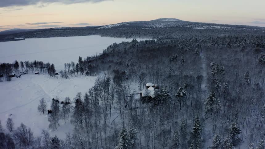 An aerial view of a wooded area covered in snow