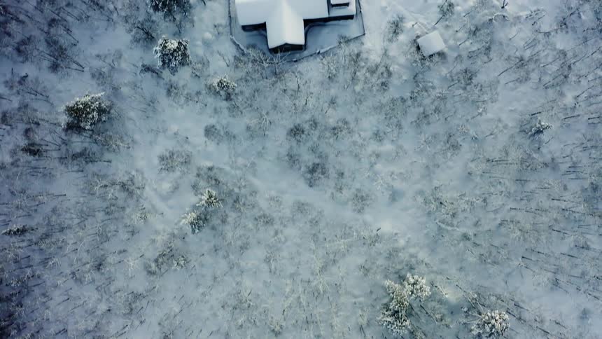 A birds eye view of a home in a rural arctic area covered in snow