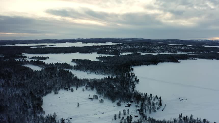 A farm stead lies in the middle of a snow covered forest