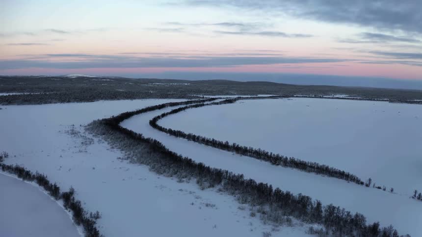 An aerial view of an arctic area is displayed at dusk