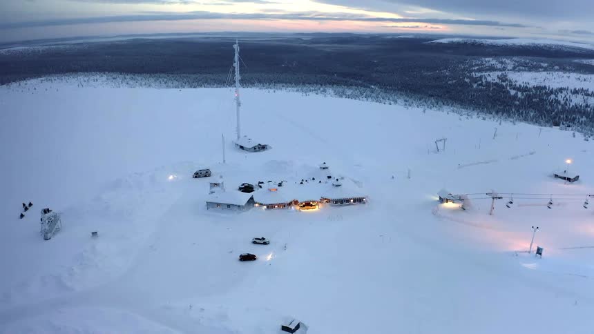 Buildings and cars at the top of a ski hill