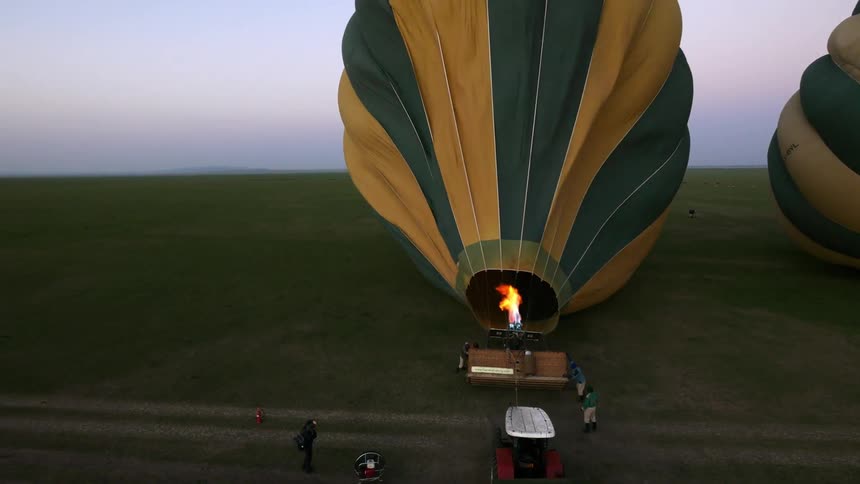 A hot air balloon is being filled on a cloudy day