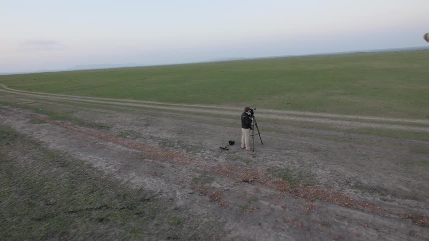 Photographer taking pictures of hot air balloons floating in the distance