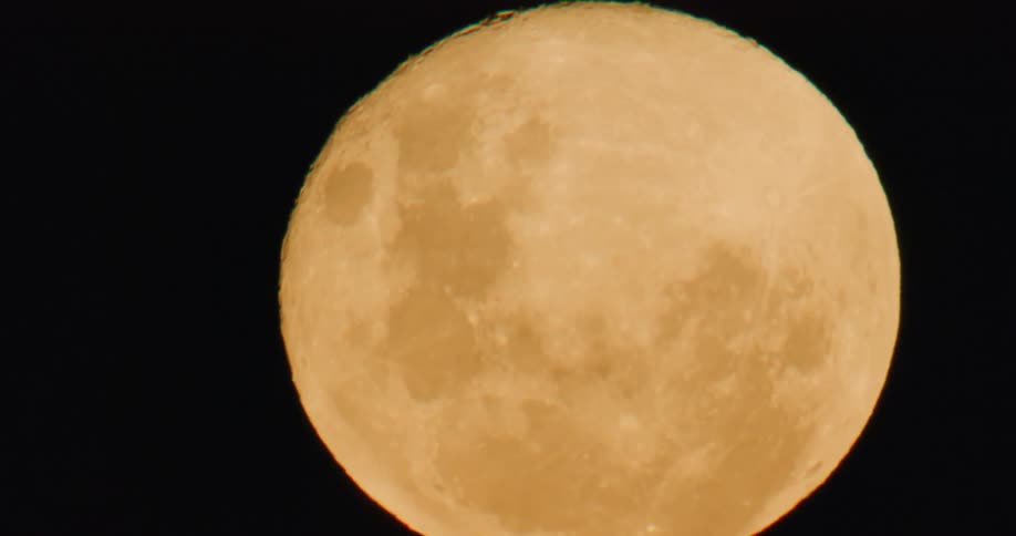A full moon with the dark sky in the background