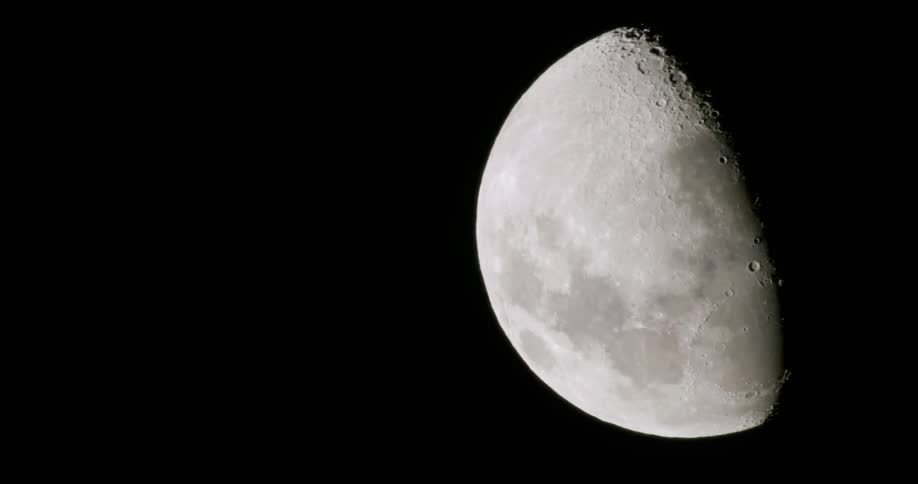 The moon with craters with the dark sky in the background
