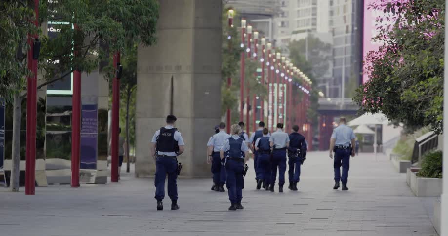 A group of police walk down a large city street