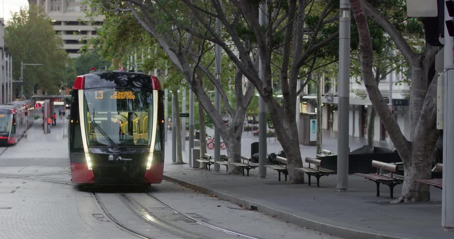 A subway driving down a city street