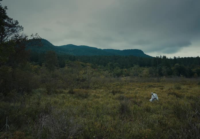A person is hiking through a grassland area