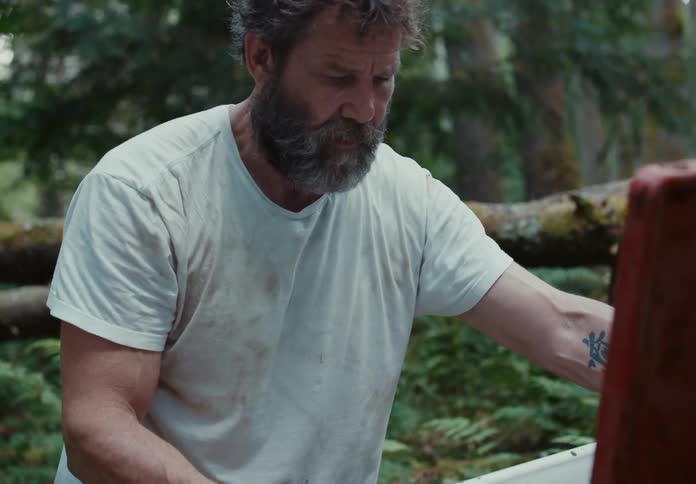 A man opens up a box in the woods