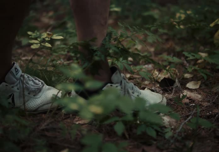 Close view of persons feet walking carefully through forest