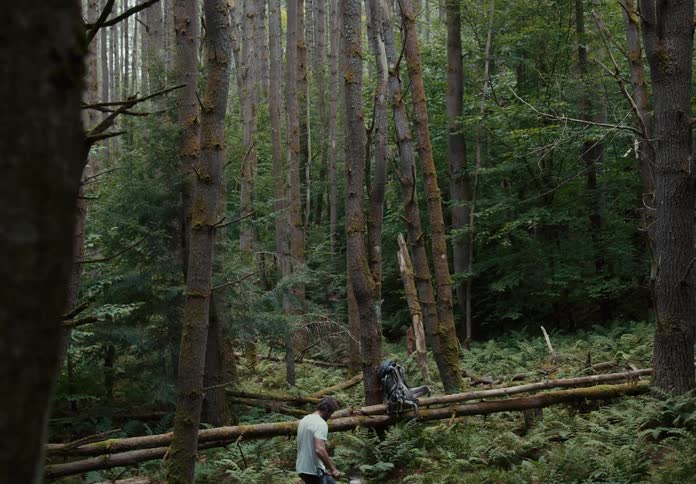 Man with a shovel in his hands counts his steps in the forest