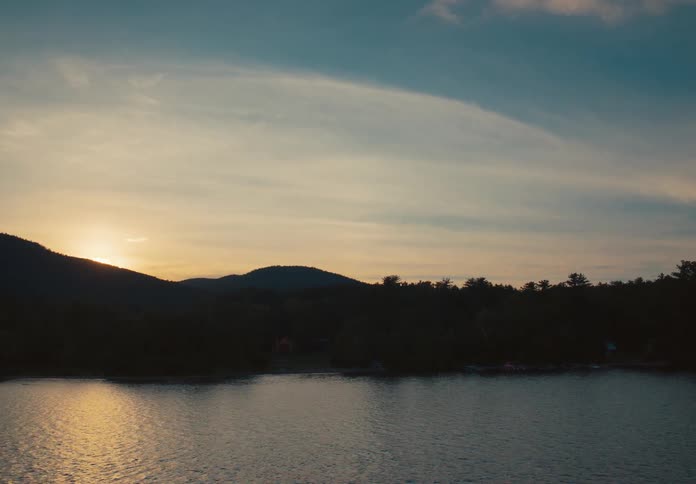A person paddleboarding on a quiet lake