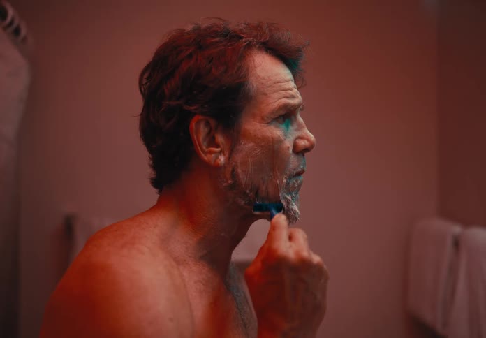 Man shaving with disposable razor in bathroom