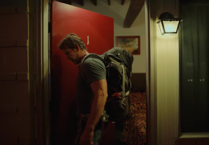 A man looks around a hotel room as he leaves
