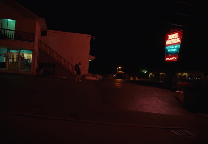 A man checks into a motel and goes outside to go to his room
