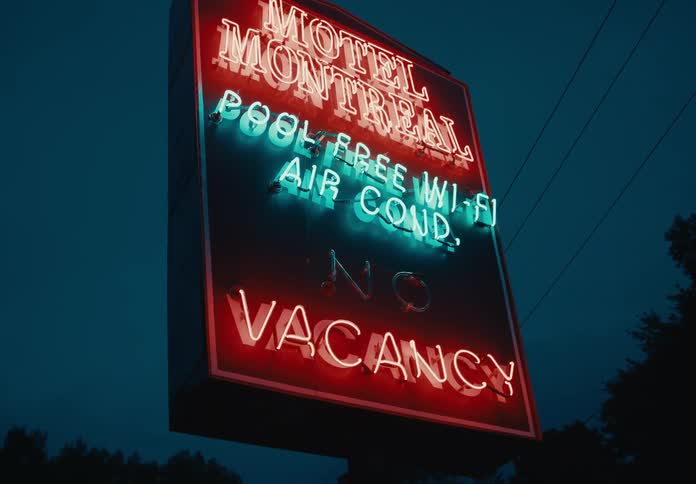 Neon motel vacancy billboard at night