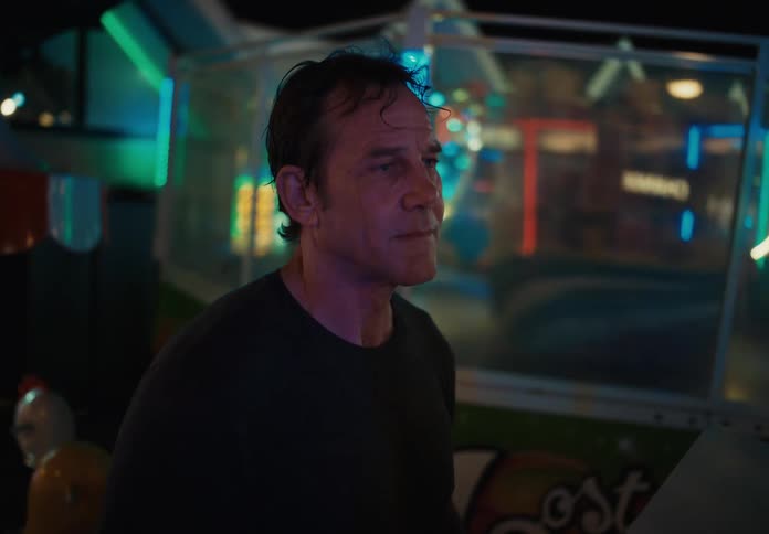 Man at the controls of an amusement park ride at night