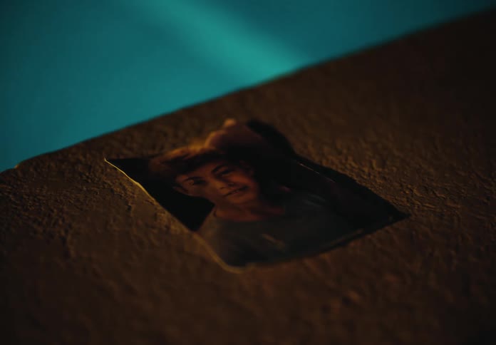 A photograph of a boy lies on a concrete surface