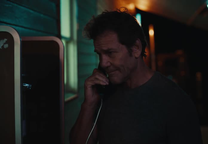 A man uses a pay phone outside a business