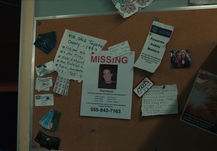 A flier about a missing man hangs on a bulletin board in an apartment building