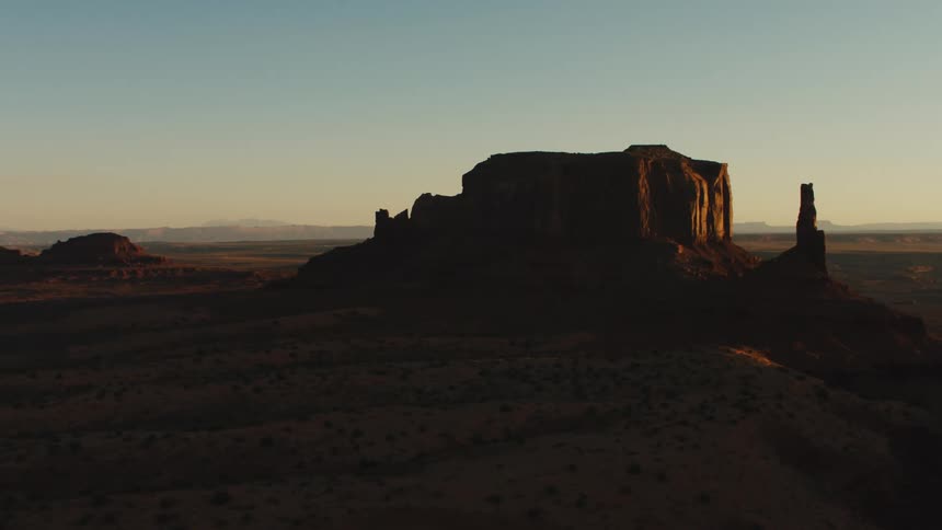 The sun sets over a field and canyon