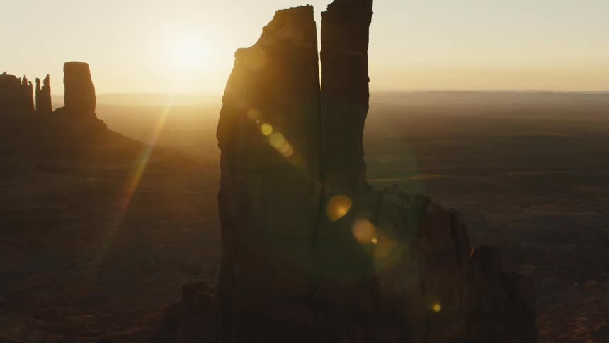 Rock spires are outlined against the low sun