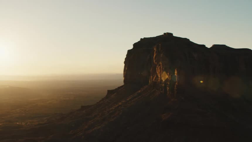 A desert with plateaus and cliffs with the sky and clouds in the background