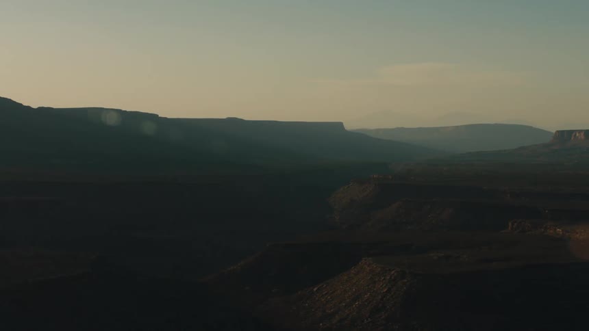 Aerial view of mesas and canyons in the desert badlands at sunset