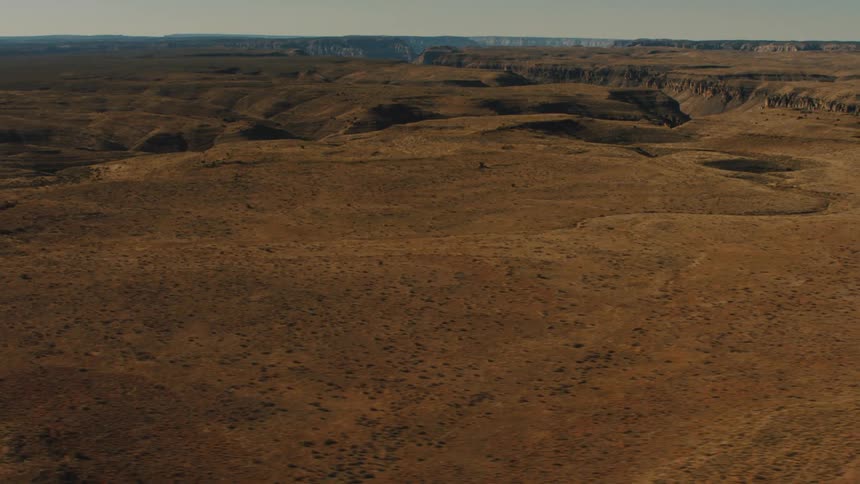 A barren plateau is visible in the midday sun