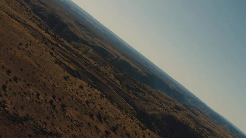 A canyon with rocks plants and the sky in the background