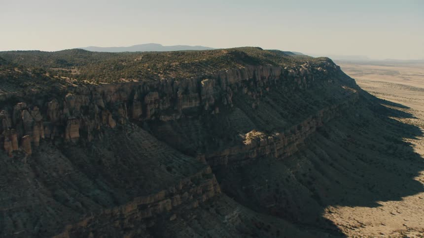 Trees and bushes cover the top of a plateau in the canyon