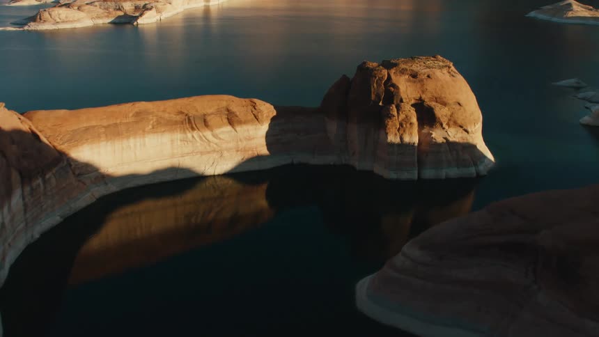 A calm blue lake lies in a rocky area