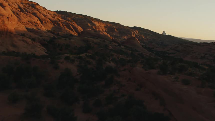 Aerial view of a valley between mesas in the badlands desert at sunset