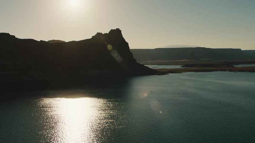 A body of water with a cliff on the coast