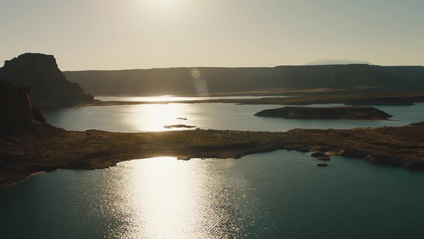 Sun reflects off the lake near the mountains