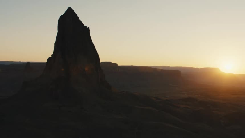 A tall rock formation towers above a desolate landscape