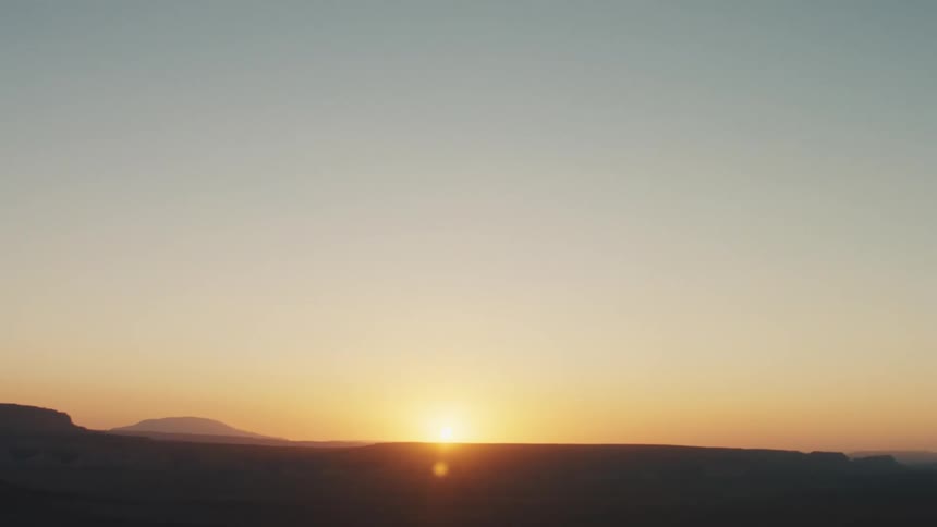 Sun sets in the horizon over the desert plains