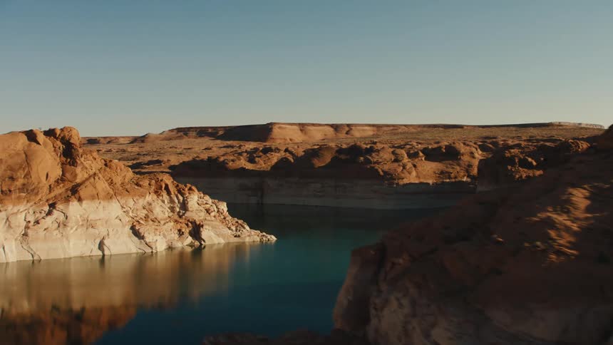 A lake in a desert with cliffs and the sky in the background