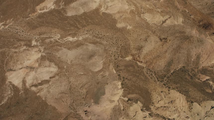 A dirt road winds through a desert canyon